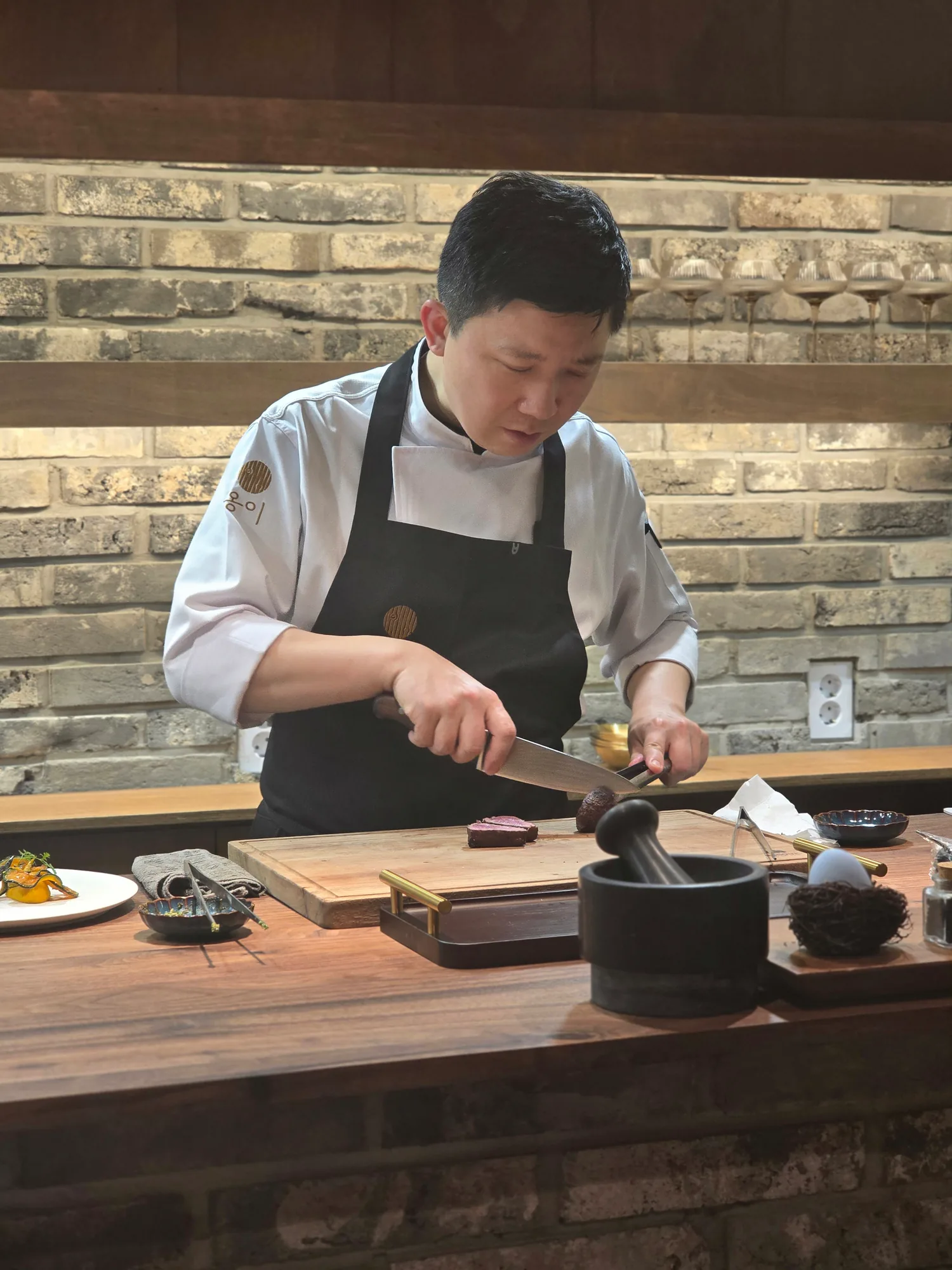 옹이의 김원기 셰프가 카운터에서 직접 요리를 다듬는 모습